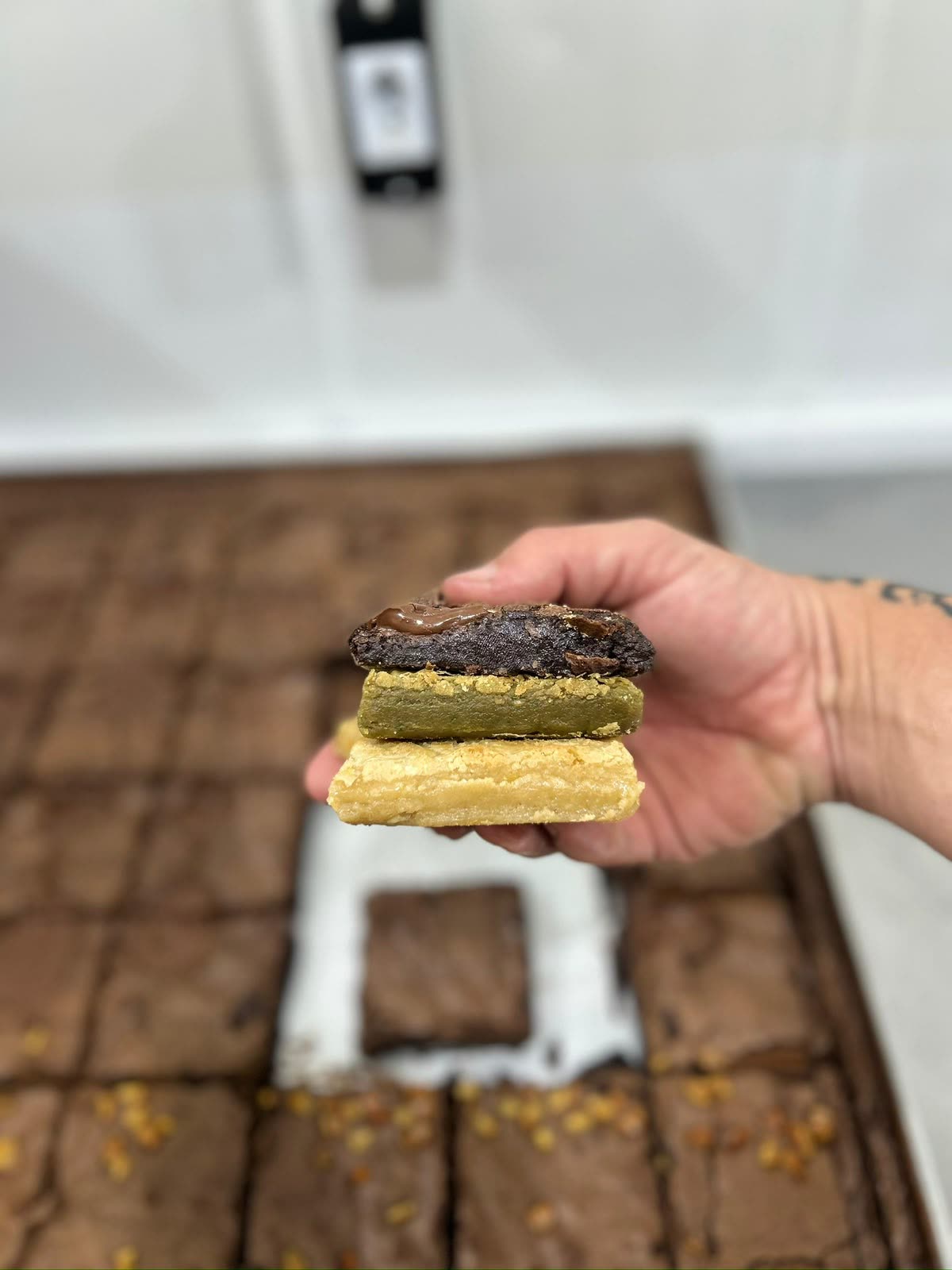 Trio de brownie, blondie de pistache e blondie tradicional empilhados