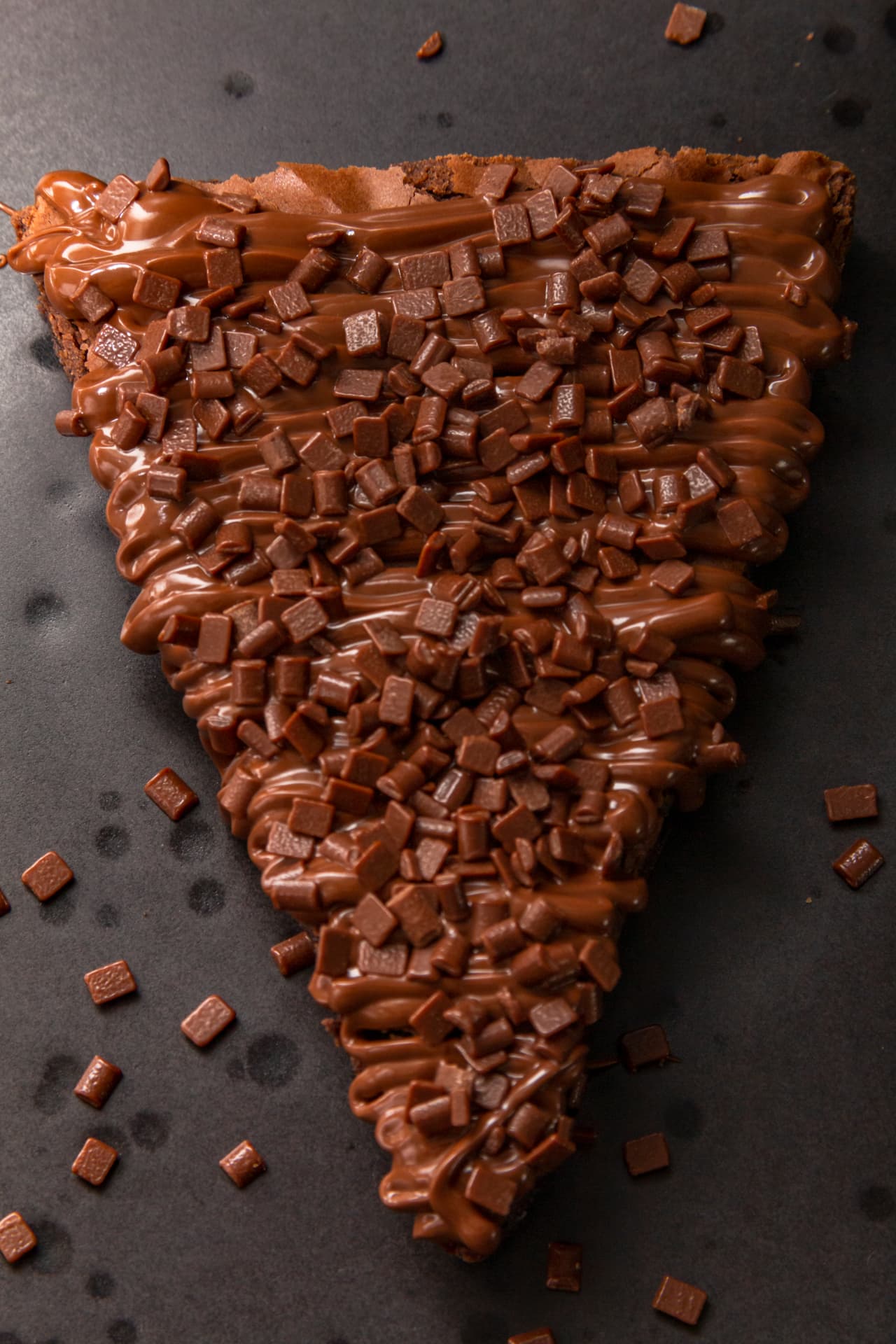 Fatia de brownie coberta com calda de chocolate e granulado, capa do ebook O Brownie Perfeito